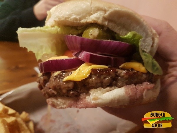 Nahansicht eines Cheeseburgers belegt mit Zutaten